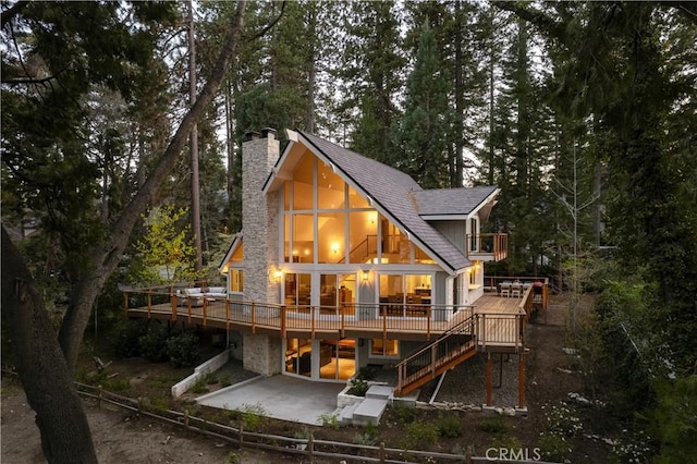 back of property with a patio, a chimney, stairs, and a deck