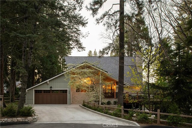rustic home featuring concrete driveway and an attached garage
