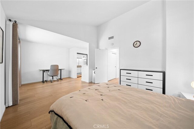 bedroom featuring baseboards, high vaulted ceiling, visible vents, and wood finished floors