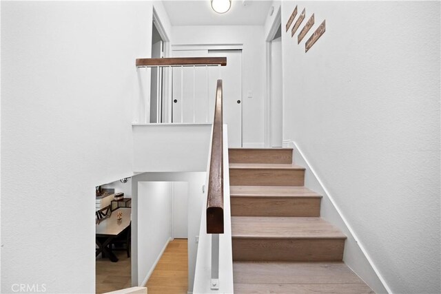 stairs featuring wood finished floors