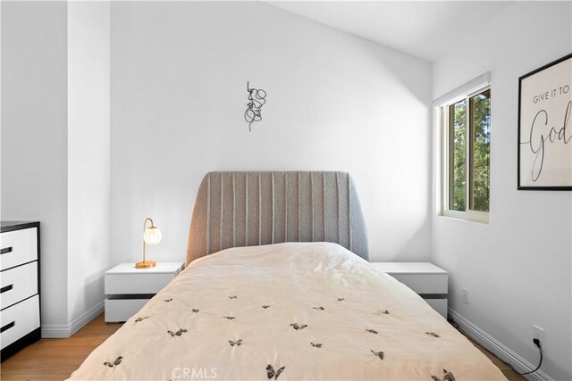 bedroom with baseboards and wood finished floors