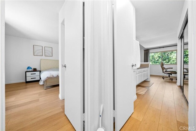 hallway with baseboards and light wood finished floors
