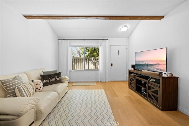 living room featuring baseboards, lofted ceiling with beams, and light wood-style flooring