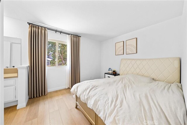 bedroom featuring baseboards and light wood finished floors
