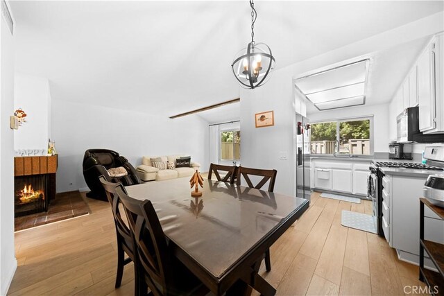 dining room featuring light wood finished floors and a multi sided fireplace