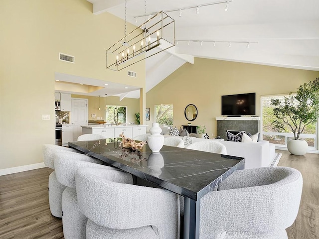 31062 Flying Cloud Dr, Laguna Niguel, CA 92677 - dining space with track lighting, wood finished floors, visible vents, and high vaulted ceiling