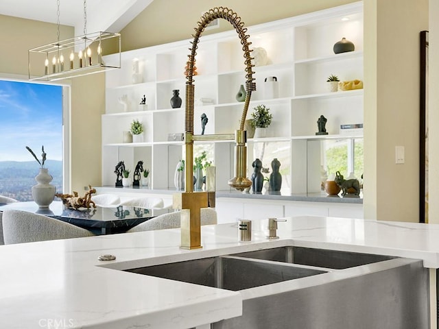 31062 Flying Cloud Dr, Laguna Niguel, CA 92677 - kitchen featuring open shelves, light stone counters, an inviting chandelier, a sink, and pendant lighting