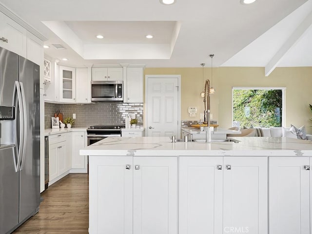 31062 Flying Cloud Dr, Laguna Niguel, CA 92677 - kitchen featuring appliances with stainless steel finishes, tasteful backsplash, a raised ceiling, recessed lighting, and white cabinetry