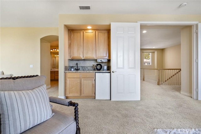 2438 Vista Del Sol Ln, Verne, CA 91750 - kitchen with arched walkways, refrigerator, light carpet, and light brown cabinetry