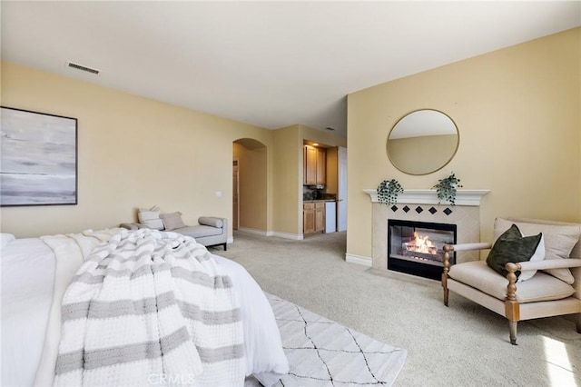2438 Vista Del Sol Ln, Verne, CA 91750 - bedroom featuring light carpet, arched walkways, a tiled fireplace, baseboards, and visible vents