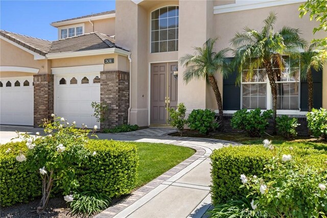 2438 Vista Del Sol Ln, Verne, CA 91750 - doorway to property with a tiled roof, brick siding, an attached garage, and stucco siding