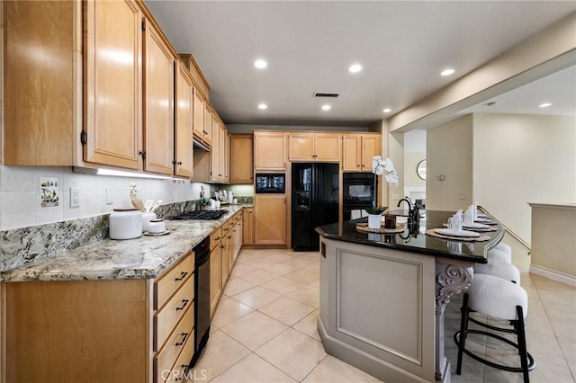 2438 Vista Del Sol Ln, Verne, CA 91750 - kitchen with light tile patterned floors, stone counters, black appliances, and visible vents