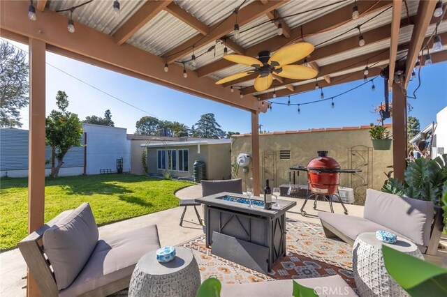 view of patio featuring ceiling fan and an outdoor living space with a fire pit