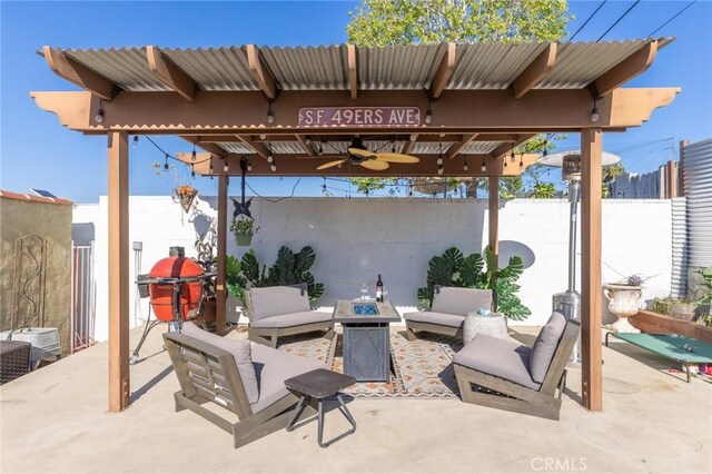 view of patio featuring a fenced backyard, ceiling fan, and an outdoor living space with a fire pit