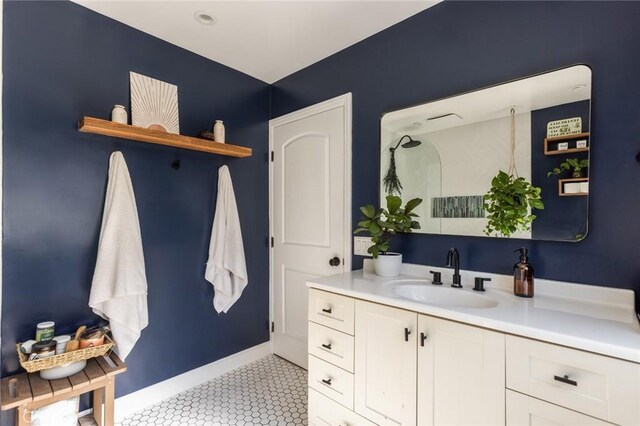 bathroom with baseboards, tile patterned flooring, and vanity