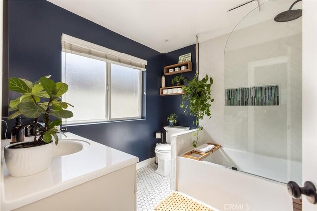 bathroom featuring a bathtub, a shower, baseboards, vanity, and toilet
