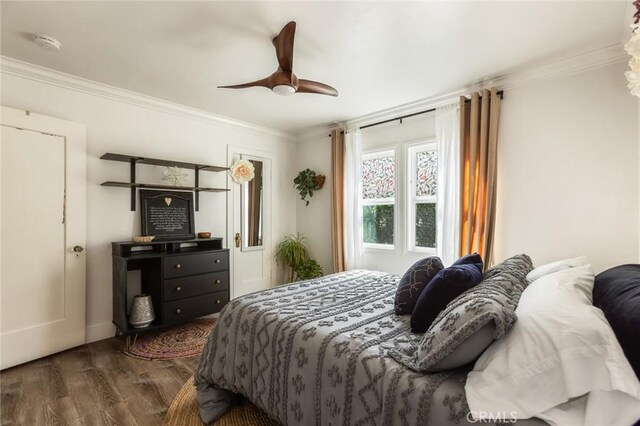 bedroom with baseboards, ceiling fan, ornamental molding, and wood finished floors