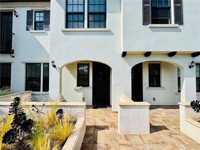 view of front of home featuring a patio and stucco siding