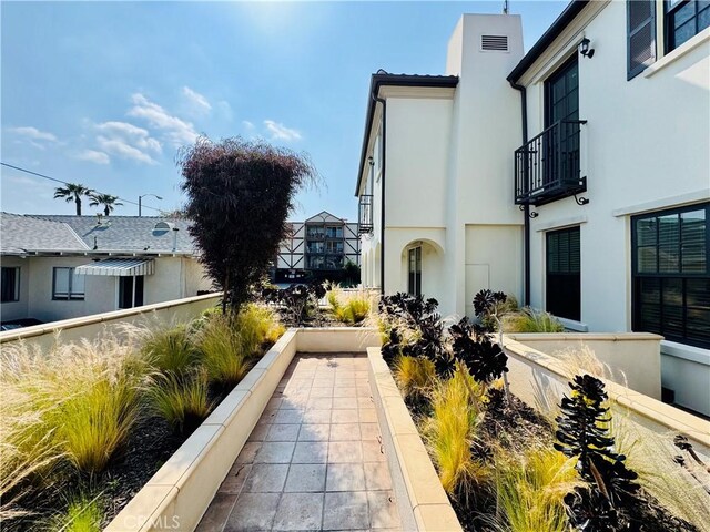 view of side of property with stucco siding and a balcony