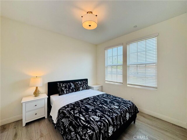 bedroom featuring baseboards and wood finished floors