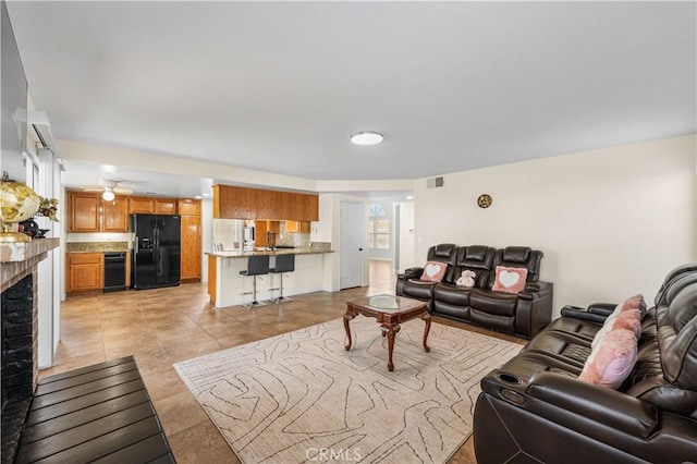 living room with a brick fireplace and visible vents