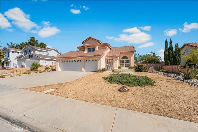traditional home featuring fence, an attached garage, a tile roof, stucco siding, and concrete driveway