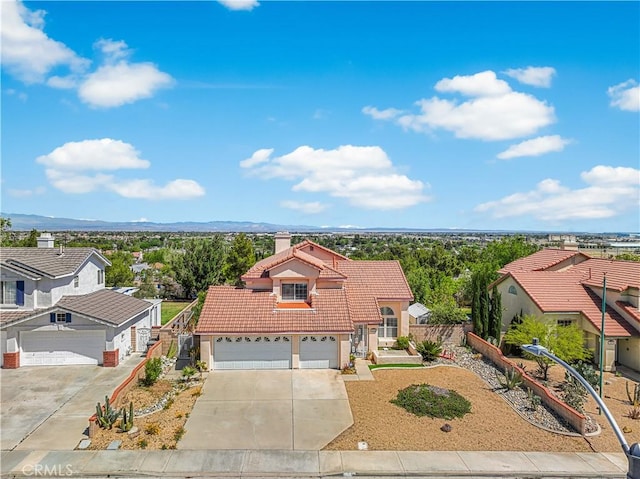 view of front of house with fence, stucco siding, a chimney, concrete driveway, and a tiled roof