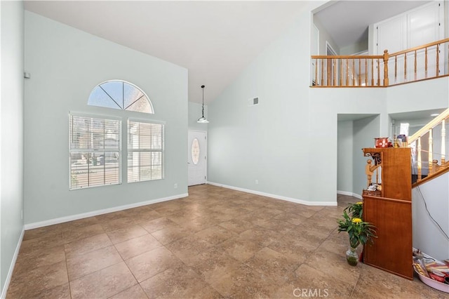 unfurnished living room featuring visible vents, baseboards, high vaulted ceiling, and stairway