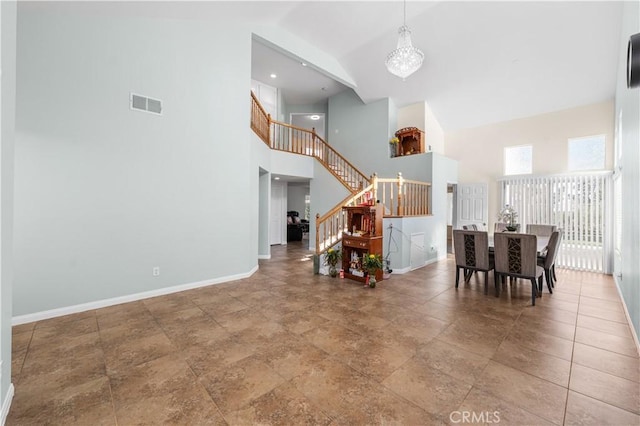 dining space featuring visible vents, stairs, baseboards, and high vaulted ceiling