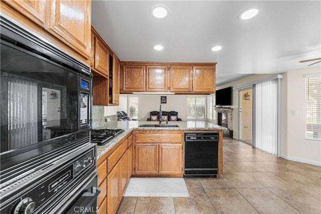 kitchen featuring a sink, baseboards, black appliances, a peninsula, and recessed lighting