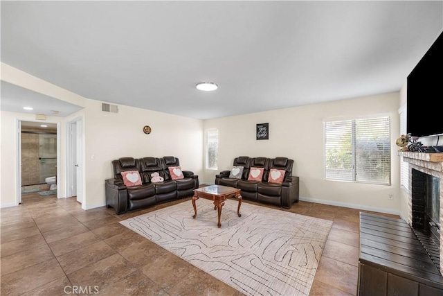 living room with baseboards, visible vents, and a fireplace