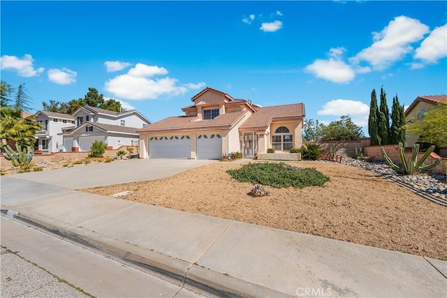 traditional-style house featuring fence, stucco siding, a tiled roof, an attached garage, and driveway