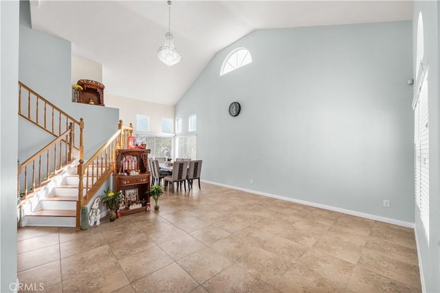 sitting room featuring baseboards, stairs, and high vaulted ceiling