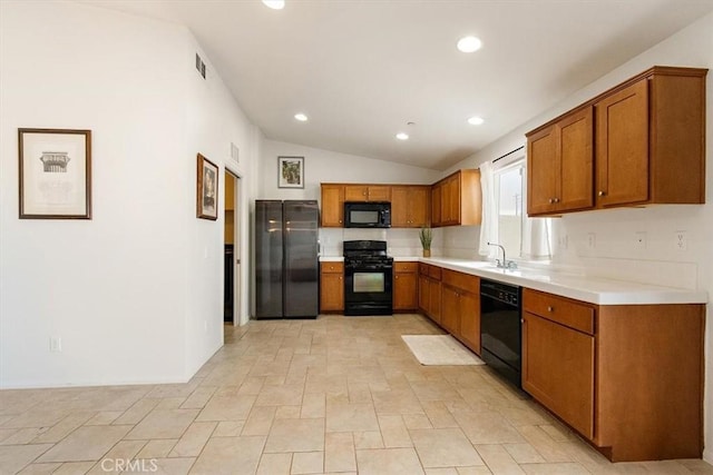 905 Broadway Ave, Barstow, CA 92311 - kitchen with brown cabinetry, recessed lighting, lofted ceiling, and black appliances