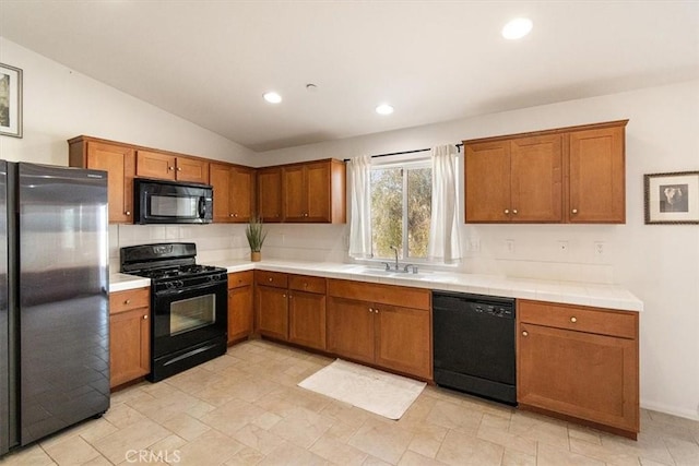 905 Broadway Ave, Barstow, CA 92311 - kitchen featuring brown cabinetry, a sink, black appliances, lofted ceiling, and recessed lighting