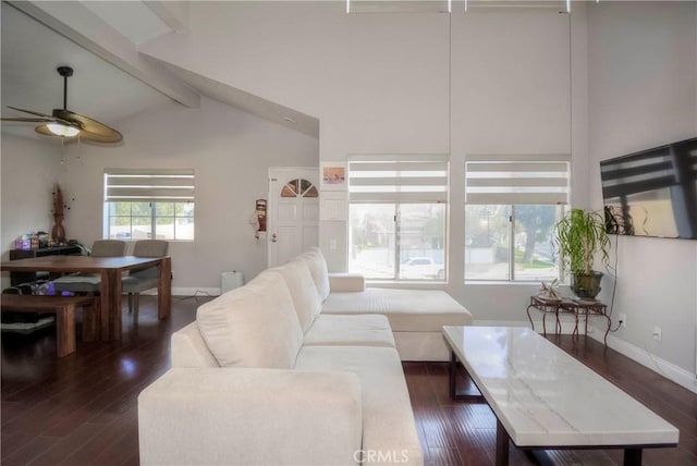 living area with baseboards, dark wood finished floors, ceiling fan, and vaulted ceiling with beams