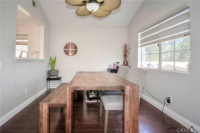 dining area with baseboards, a ceiling fan, dark wood-style flooring, and vaulted ceiling