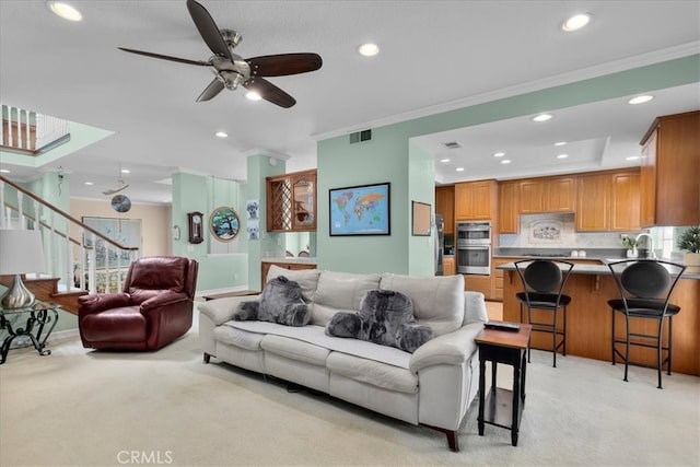 living room featuring ornamental molding, recessed lighting, and light colored carpet