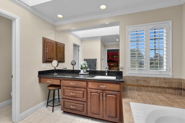 bathroom featuring vanity, ornamental molding, tile patterned flooring, a washtub, and baseboards