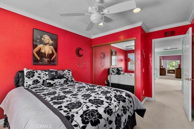 bedroom featuring crown molding, ceiling fan, carpet, visible vents, and a closet