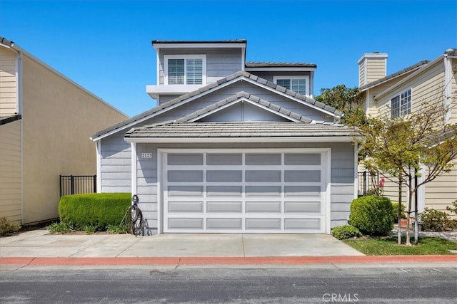 view of front of property with a garage, a tiled roof, and concrete driveway