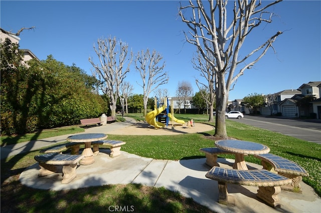 view of property's community with a lawn, a residential view, and playground community