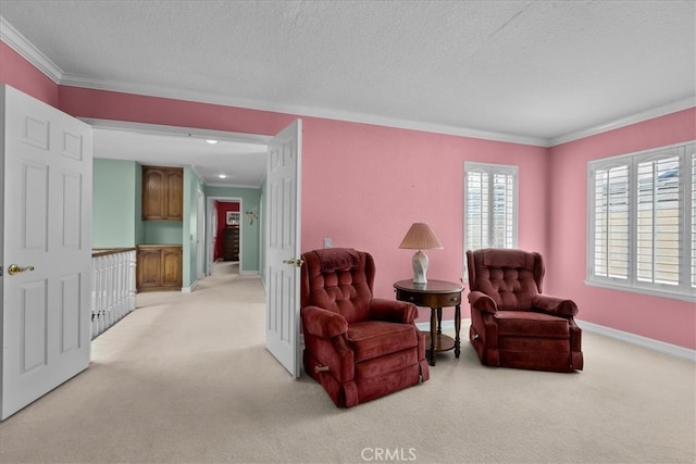 living area with baseboards, ornamental molding, a textured ceiling, and light carpet