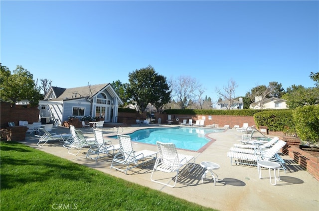pool featuring fence and a patio area