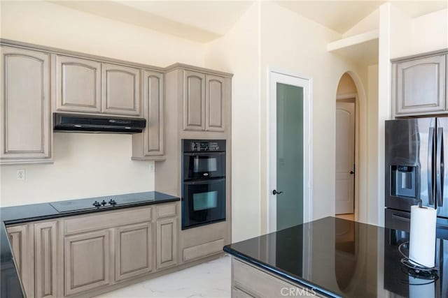 9170 Japatul Rd, Apple Valley, CA 92308 - kitchen featuring marble finish floor, dark countertops, under cabinet range hood, arched walkways, and black appliances