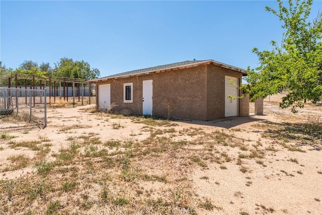 9170 Japatul Rd, Apple Valley, CA 92308 - rear view of property featuring stucco siding, fence, an outbuilding, and a detached garage