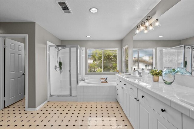 full bathroom with a sink, double vanity, a shower stall, visible vents, and a bath