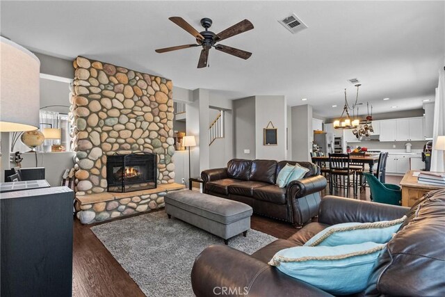 living area with a fireplace, a ceiling fan, wood finished floors, and visible vents