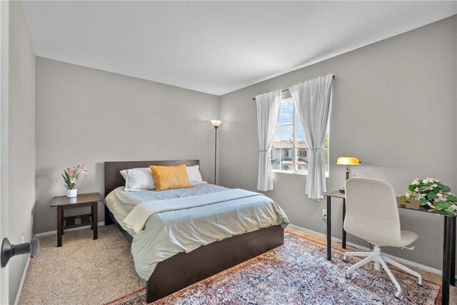 carpeted bedroom featuring baseboards