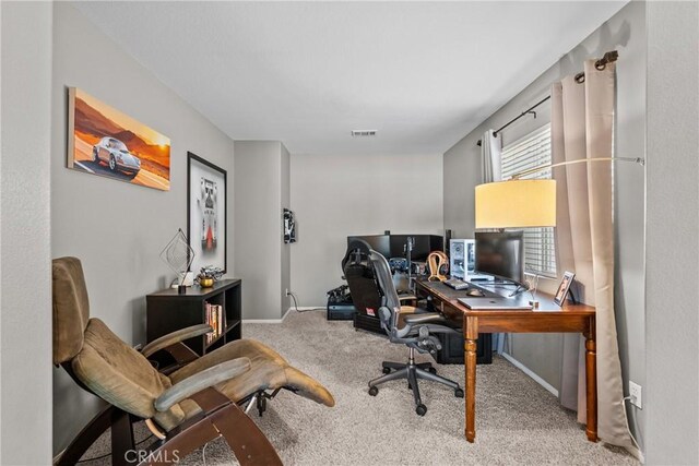 home office with carpet floors, baseboards, and visible vents